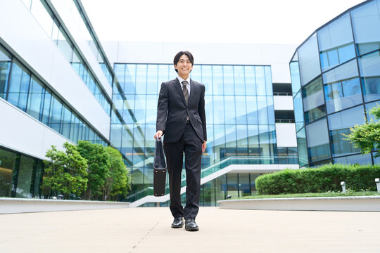 笑顔でオフィス街を歩くビジネスマン