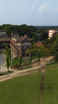 Aerial drone view of an old abandoned colonial building with overgrown grounds and surrounding
