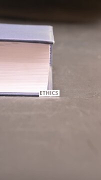 Ethics Concept on Paper Bookmark Between Books Close Up Vertical Video
