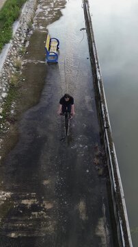 Aerial View of Person Cycling on Narrow Path Along Canal