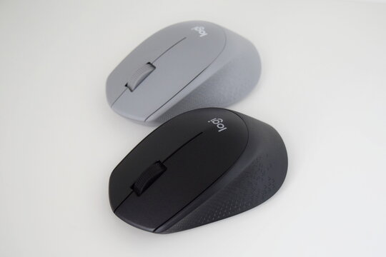 Two Logitech M330 Silent Plus wireless computer mice, in grey and black colors 