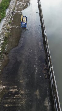 Aerial View of Man Cycling Through Flooded Path