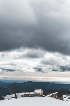 dramatic landscape in lessinia with dark clouds and lonely stone house