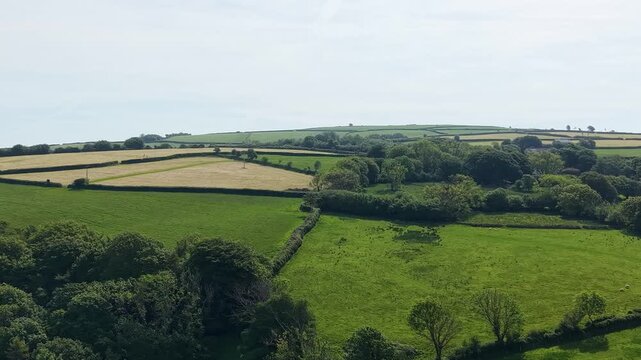 Sideways Aerial Over English Countryside with Green Trees and Fields During Spring.