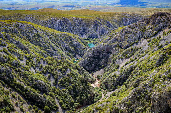 A breathtaking panorama of Zrmanja Canyon showcases dramatic limestone cliffs, rugged karst terrain and Mediterranean vegetation in northern Dalmatia. The scenic Croatian destination.
