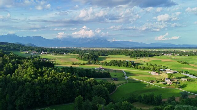 Drone flight over the green field with a view of mountains