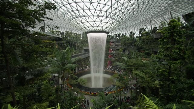 Spectacular interior of Changi Airport in Singapore featuring futuristic bionic architecture tropical greenery and a breathtaking indoor waterfall in Asia