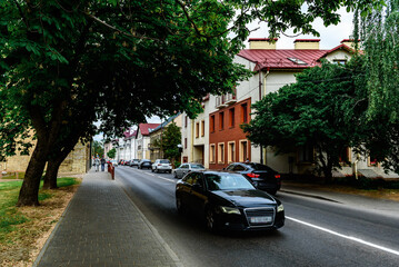 Obraz premium Traffic cars on road of city avenue on sunny day.