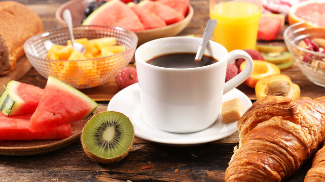 Healthy continental breakfast with coffee cup croissant and fresh fruits on wood