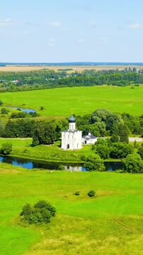Vertical video. S-Log. Russia, Bogolyubovo. Drone footage of Church of the Intercession on the Nerl. Orthodox church and a symbol of medieval Russia. Drone footage, Point of interest. Rich colors