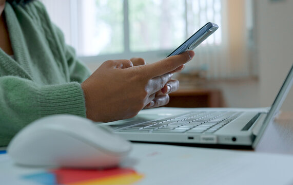Asian woman using smartphone at home, working at home