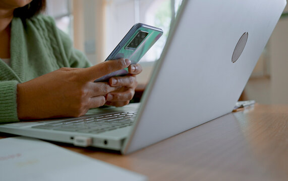 Asian woman using smartphone at home, working at home