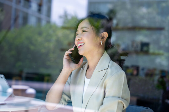 Asian businesswoman uses a smartphone for work.