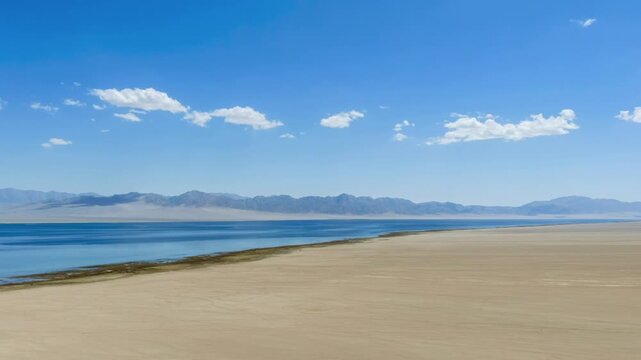 Aerial Time-Lapse of Sugan Lake in Gansu Province with Desert Shoreline and Distant Mountains  