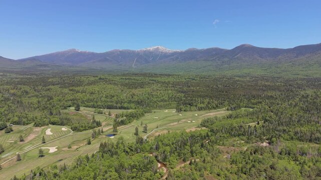 Tilted up aerial fly from distant snowy peak Mount Washington at endless White Mountain National Forest environment, New Hampshire, United States