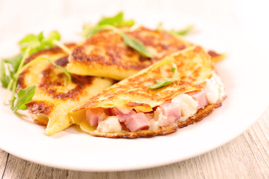Savory potato pancakes stuffed with ham and melted cheese on plate