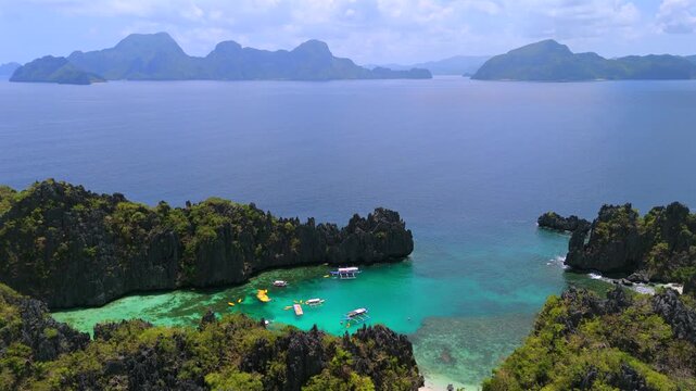 Drone view of boats and kayaks in a turquoise El Nido lagoon