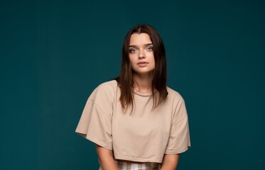 Obraz premium Young brunette woman posing in studio, wearing casual attire, looking directly at camera with natural expression