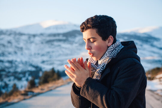 Teenage boy rubbing cold hands