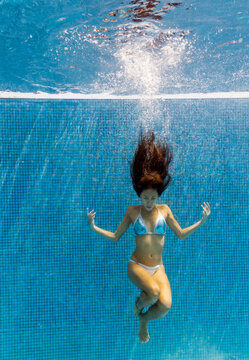 Woman enjoys peaceful solitude floating underwater in a pool