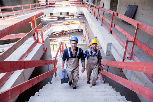 Two construction workers on construction site walking upstairs