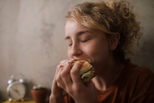 Portrait of young woman eating Hamburger