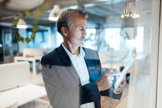 Senior businessman using digital tablet in office