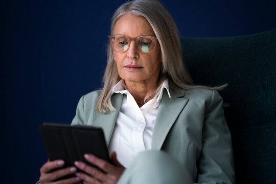 Businesswoman using tablet PC against blue background