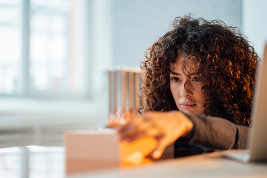 Young engineer with curly hair examining semiconductor