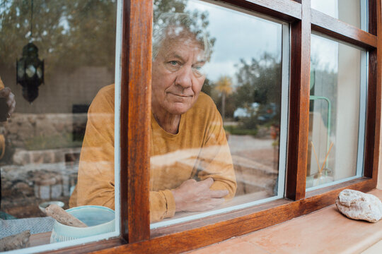 Smiling senior man seen through window