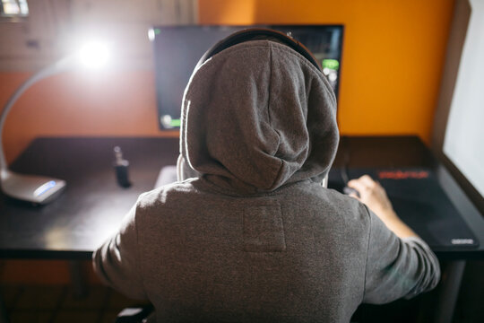 Young man sitting at his PC, playing computer games