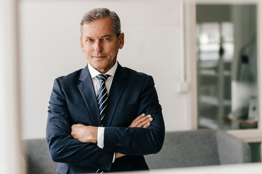 Portrait of mature businessman with arms crossed in his office