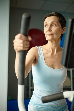 Woman uses an elliptical machine for rehabilitation and fitness