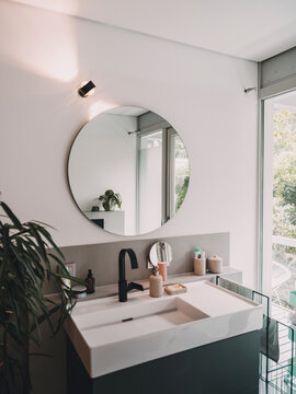 Modern luxury bathroom interior with sink and round mirror