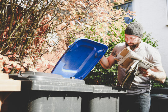 Man recycling waste paper in paper bank
