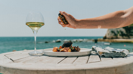 Grilled octopus dish with seasoning and white wine on a wooden table © Reuben