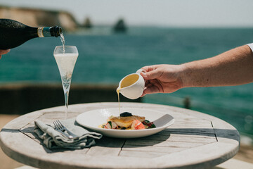 Elegant seaside dining experience with champagne and gourmet food © Reuben