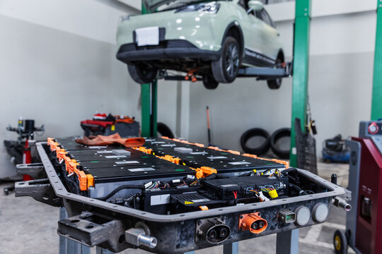 High-voltage battery pack removed from an electric vehicle during maintenance in a modern EV service center.