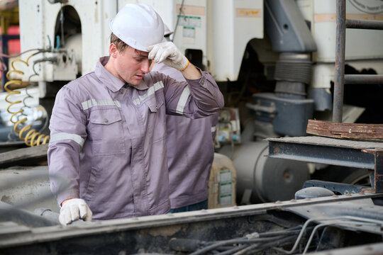 Worker feeling tired from work on a large vehicle
