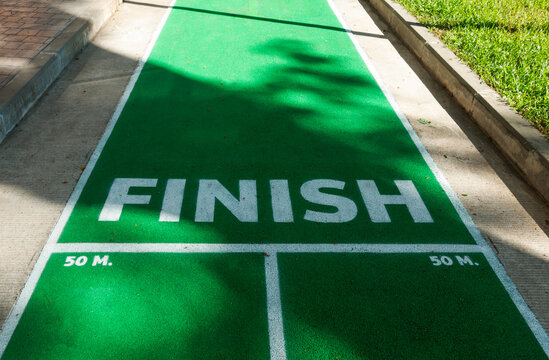 green running path with white FINISH text with shadows, concept of business success and achieving goals.