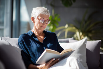 Elegant senior woman reading book at home healthy aging relaxation and active lifestyle