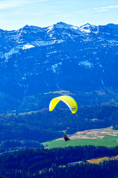 Gleitschirmflieger im Bregenzerwald mit Blick auf die Gemeinde Au und das imposante Massiv des Diedamskopfs, Vorarlberg, &Ouml;sterreich
