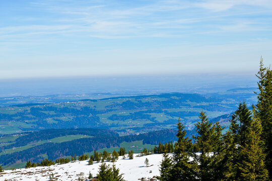Weitblick von der Niedere &uuml;ber schneebedeckte H&auml;nge auf das gr&uuml;ne H&uuml;gelland des Bregenzerwaldes im Fr&uuml;hling, Vorarlberg, &Ouml;sterreich