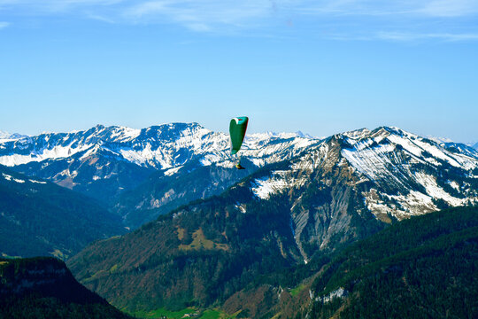 Gleitschirmflieger im Bregenzerwald mit Blick auf die Gemeinde Au und das imposante Massiv des Diedamskopfs, Vorarlberg, &Ouml;sterreich