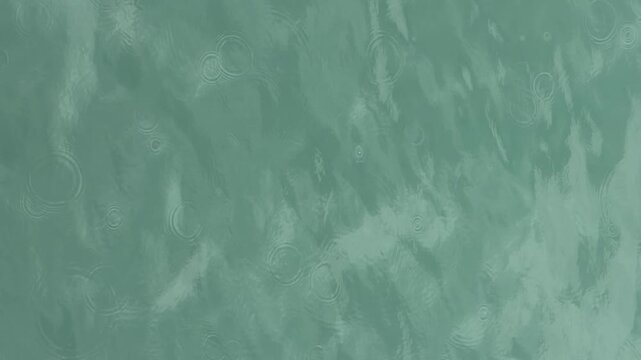 Gentle ripples on the surface of calm, teal-colored water create a serene and tranquil abstract background.Concentric circles spread across the tranquil teal water surface, indicating gentle disturban