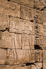 Fototapeta premium Detailed stone relief carvings of ancient Egyptian figures on a wall at Luxor Temple Egypt