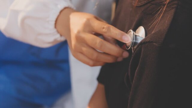 Doctor use stethoscope, checking up heart beat, auscultation in doctor office at hospital. Patient worker has to get medical checkup every year for her health