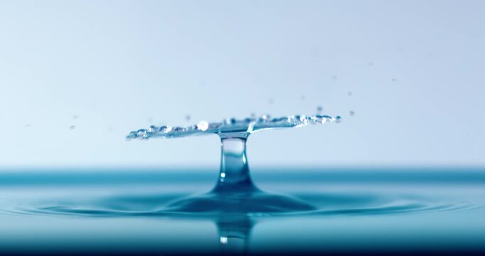 Blue Water Droplet Impact Forming Liquid Umbrella Shape with Ripple Reflection Macro Background