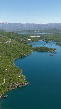 Vertical Drone Shot of Slano Lake Rugged Coastline, Water Reservoir and Green Landscape of Montenegro