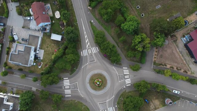 Aerial view of Dambach-La-Ville, France. A tracking shot of a residential area and green fields and a recreational park with bike track among the buildings.